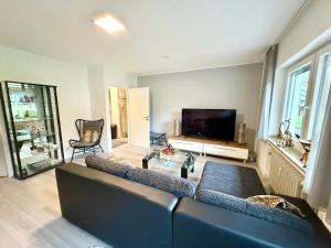 a living room with a couch and a tv at Gemütliches Apartment mit Blick ins Grüne nähe Messe in Meerbusch