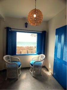 a room with chairs and a window with a view of the ocean at Casa Del Mar - Sea Facing Villa in Cochin