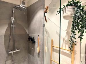 a bathroom with a shower with a plant on the wall at Copenhagen Collection King s Garden Studio in Copenhagen