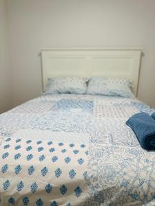 a bed with a blue and white comforter and pillows at Cozy Homez Ballarat - Home stay in Alfredton +13 photos