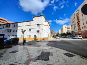 eine leere Straße mit einem weißen Gebäude an der Ecke in der Unterkunft Huelin playa in Málaga