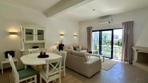 ein Wohnzimmer mit Sofa und Tisch in der Unterkunft Jardim da Oura 2 by Check-in Portugal in Albufeira
