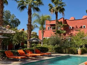 a resort with a pool and chairs and palm trees at Le Palais Mandarine in Taroudant