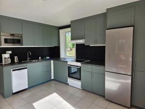 a kitchen with blue cabinets and white appliances at Villa Fridhem in Vaggeryd