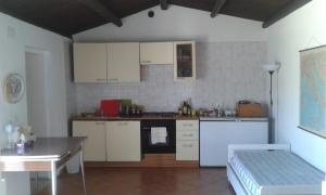 una cocina con armarios blancos y una mesa en una habitación en Su Furriadroxu Tuerredda, en Teulada 28 fotos más