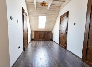 an empty hallway with wooden floors and doors at Ozónia Wellness House in Šahy