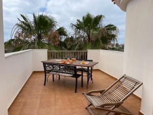 un tavolo e sedie su un balcone con palme di Villa A70 by Alina365 a La Manga del Mar Menor