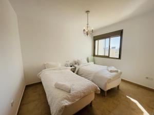 due letti in una stanza bianca con una finestra di Villa A70 by Alina365 a La Manga del Mar Menor Altre 28 foto