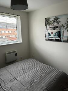 a bedroom with a bed and a picture of a van at Ferry Gait Apartments in Edinburgh