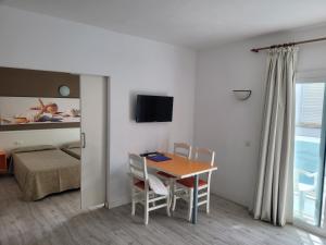 a room with a table and chairs and a bed at Apartamentos Arcadio in El Arenal