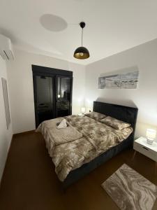 a bedroom with a large bed in a room at Hill Apartment in Podgorica