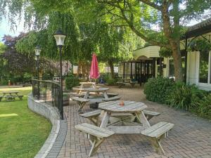 a group of picnic tables and a pink umbrella at Tolroy manor holiday cottage in Saint Erth
