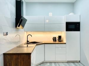 ミエンジズドロイェにあるMiędzyzdrojski Rynek by Baltic Homeの白いキャビネットとシンクのあるキッチン +22枚の写真