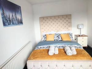 a bedroom with a large bed with yellow and blue pillows at Comfort Palace in Newcastle upon Tyne +2 photos