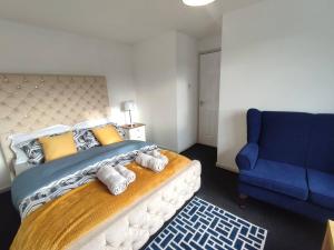 a bedroom with a large bed and a blue couch at Comfort Palace in Newcastle upon Tyne