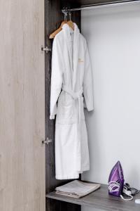 a white robe is hanging on a wall at Infinity Plaza Hotel in Atyraū