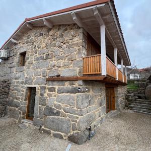 a stone building with a balcony on top of it at Casa da Bá in Puxedo
