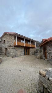 a stone house with a balcony on top of it at Casa da Bá in Puxedo