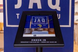 a framed picture of a check in sign with a plant at Hostel JAQ takamatsu in Takamatsu