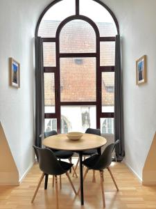 a table and chairs in a room with a large window at Premium maisonette in city center with parking in Braunschweig