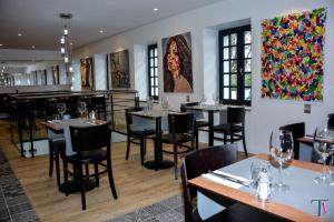 un restaurante con mesas, sillas y pinturas en la pared en Le Matisse Pau Centre, en Pau