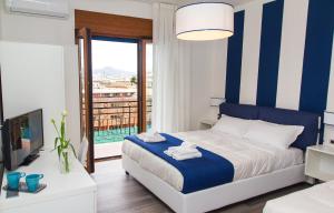 Schlafzimmer mit einem Bett mit blauen und weißen Streifen in der Unterkunft Sea Room Sorrento in Sorrent