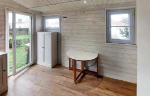 a small kitchen with a table and a refrigerator at Awesome Home In Barbatre in Barbâtre