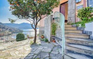 a white gate in front of a house with an orange tree at Stunning Apartment In Recco With Wifi in Recco