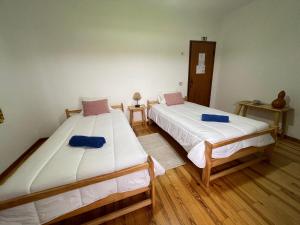 two beds in a room with wooden floors at Residencial Borges in Condeixa a Nova