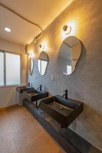 a bathroom with three sinks and a mirror at Hostel JAQ takamatsu in Takamatsu