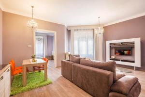 a living room with a couch and a tv at Two Couples Apartment in Budapest