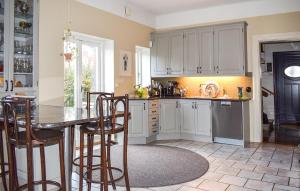 eine Küche mit weißen Schränken und einem Tisch und Stühlen in der Unterkunft 3 Bedroom Lovely Home In Ystad in Ystad