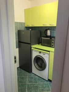 a kitchen with a refrigerator and a washing machine at One Room Apartment Ptm 2 in Bucharest