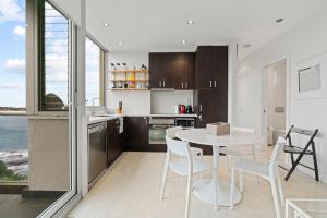 a kitchen and dining room with a table and chairs at Sparkling Bondi Views in Sydney