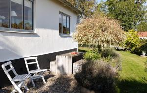 GärsnäsGorgeous Home In Gärsnäs With Wifi的庭院设有两把椅子和一张桌子,还有一棵树