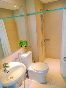Un baño con inodoro, lavabo y ducha. en Azure Condo by arlene, en Manila