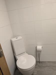 a white bathroom with a toilet and a roll of toilet paper at Cozy Cottage Close to Haworth Sleeps 2 with Garden in Keighley