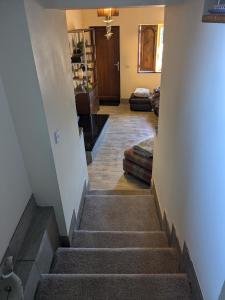 a hallway with stairs leading to a living room at Cozy Cottage Close to Haworth Sleeps 2 with Garden in Keighley