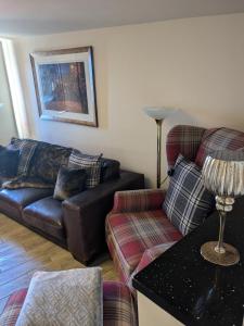 a living room with a couch and a chair at Cozy Cottage Close to Haworth Sleeps 2 with Garden in Keighley