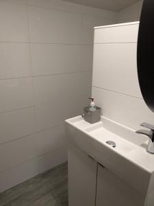 a white bathroom with a sink and a mirror at Cozy Cottage Close to Haworth Sleeps 2 with Garden in Keighley +15 photos