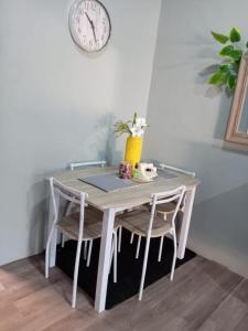 a table with two chairs and a clock on the wall at Hermosa Casa Peatonal Las Campanas in Tegucigalpa