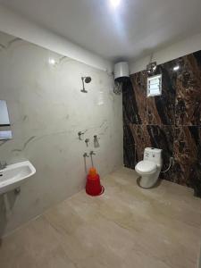 un baño con inodoro y lavabo en Prantik Hotel And Resorts, en Tajpur