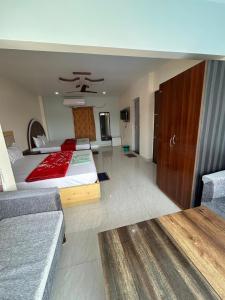 Un dormitorio con una cama grande y un sofá. en Prantik Hotel And Resorts, en Tajpur