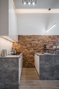 a kitchen with concrete counters and a brick wall at Rynek 2B - Old Town in Wrocław +3 photos