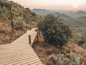 a wooden boardwalk on a hill in the mountains at Thaba eNtle Private Boutique Game Farm in Thabazimbi