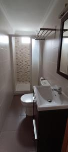 ein Badezimmer mit einer weißen Toilette und einem Waschbecken in der Unterkunft Apartamento VILLASUR in Alcalá de los Gazules