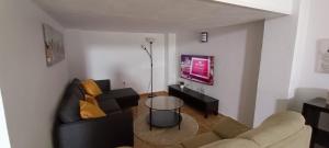 ein Wohnzimmer mit Sofa und Tisch in der Unterkunft Apartamento VILLASUR in Alcalá de los Gazules