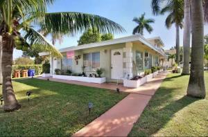 een huis met palmbomen ervoor bij BEACH Zen Oasis-walk 2 beaches in Deerfield Beach
