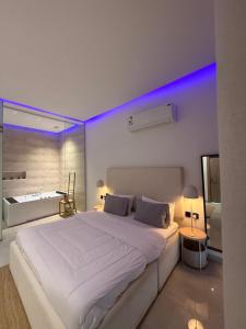 a bedroom with a large white bed with blue lights at شاليهات بالما in Al Hofuf +63 photos