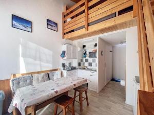 een kleine keuken met een tafel en stoelen in een kamer bij Charming duplex in La Toussuire